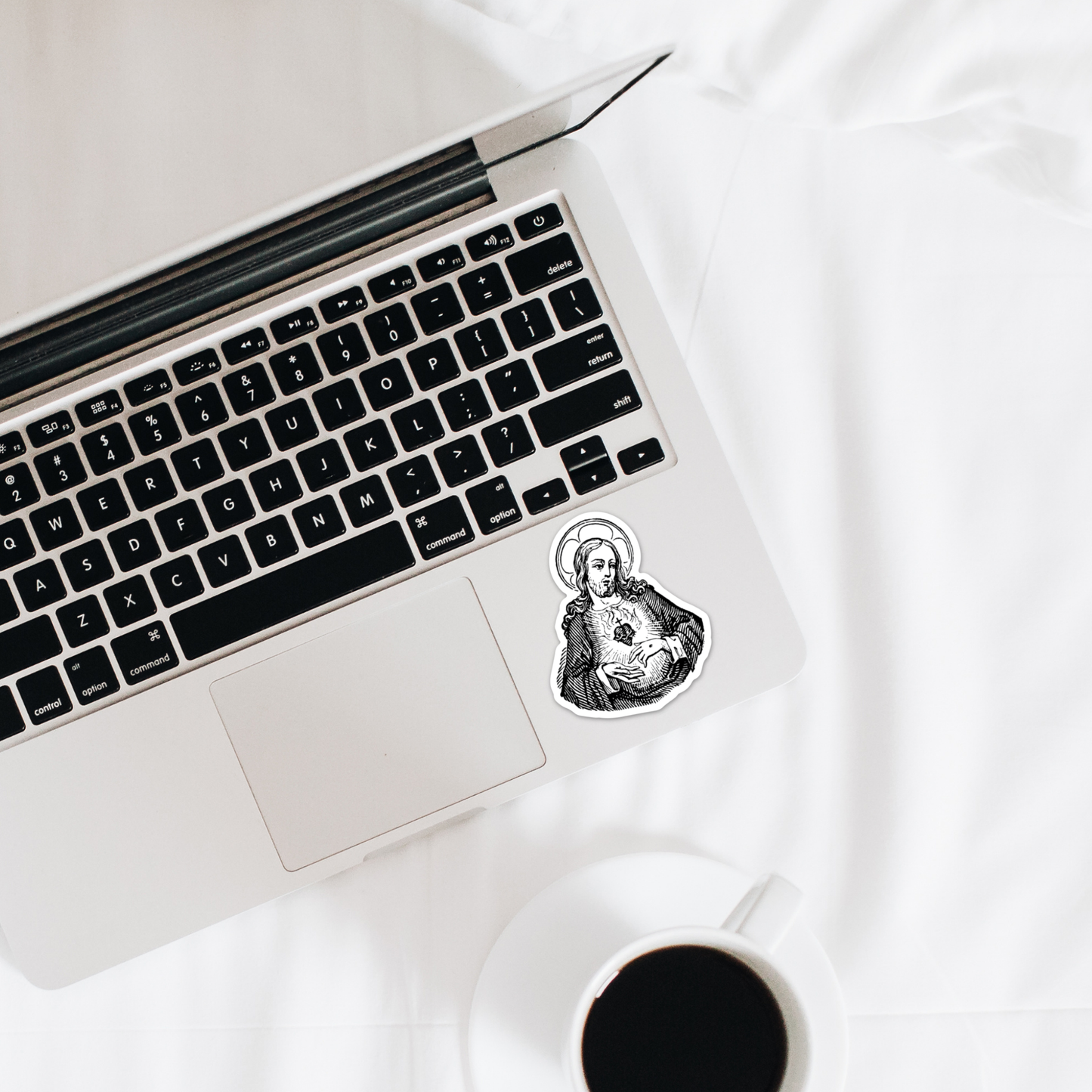 a laptop computer sitting on top of a white bed