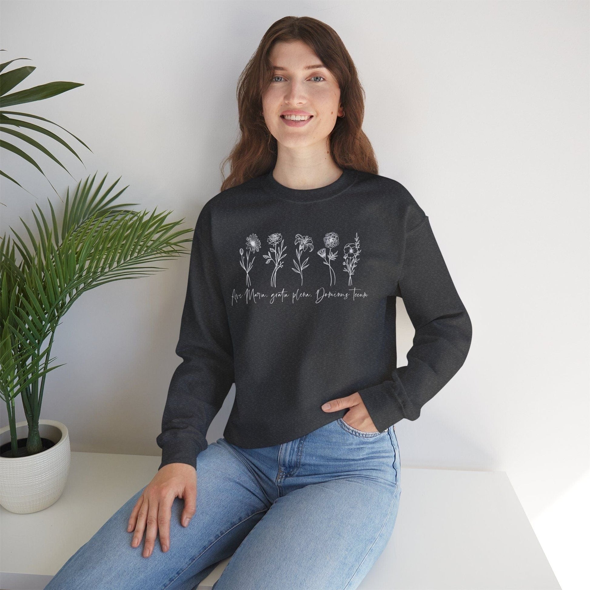 a woman sitting on a table wearing a black sweater