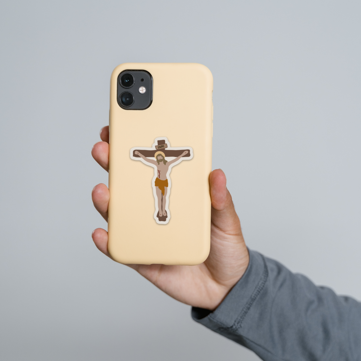 a person holding up a phone case with a cross on it