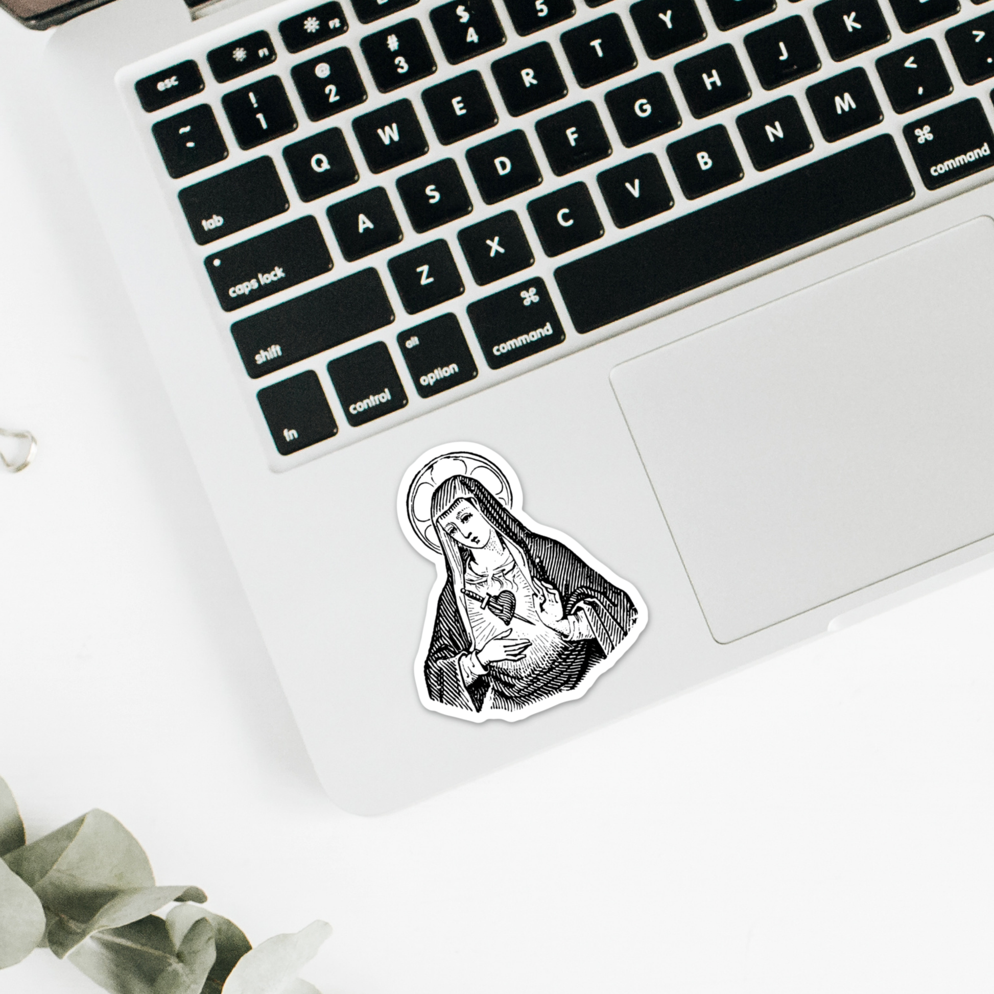 a laptop with a sticker of a virgin mary